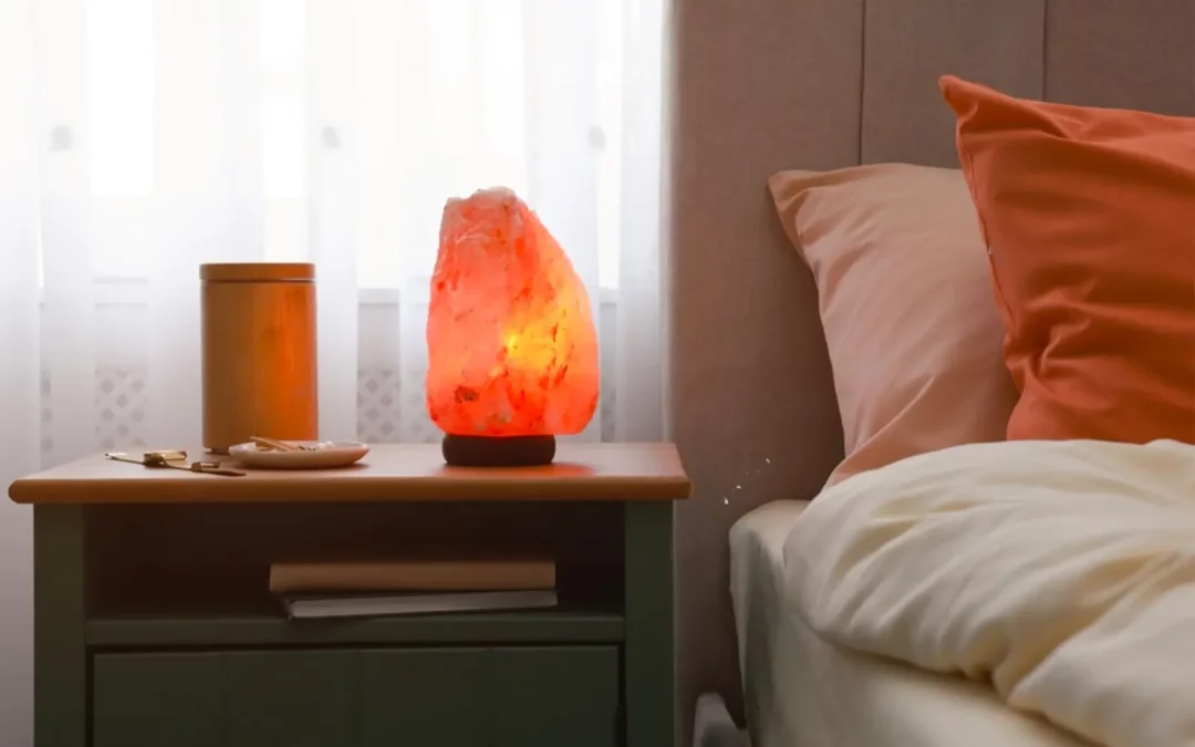 Lampe de sel sur table de chevet à côté d'un lit